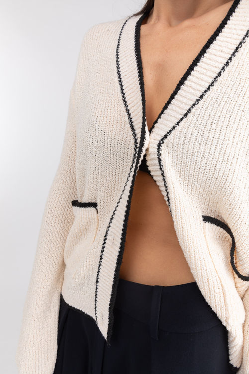 The contrast of black ribbons on textured white fabric added a gentle and  endearing vibe to this classic round neck cardigan. Find them…